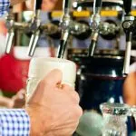 Man drawing a beer from tap on a kegerator