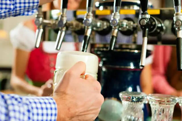 Man drawing a beer from tap on a kegerator